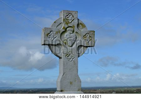 Fancy stone cross standing against the sky.