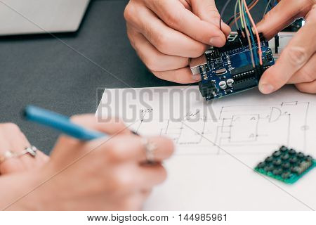Woman recapping electronics creation process. Engineer assistant drawing wiring diagram of electronic construction. Modern technologies, innovation, diy laboratory
