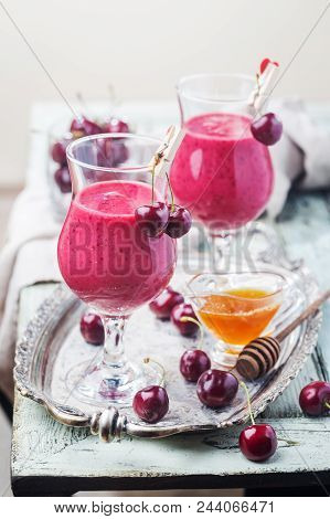 Healthy Cherry Smoothie With Frozen Strawberry, Coconat Water And Honey In Glass On White Wooden Tab