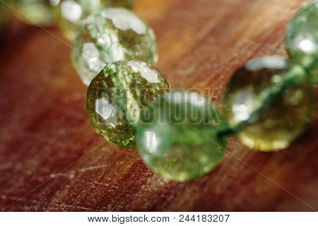 Natural Green Jade Nephrite Stones Beads On Wooden Background. Green Grassy Color Round Stone Beads 