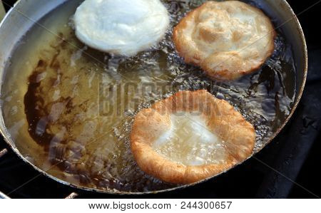Three Pancakes Cooked In The Boiling Oil Of A Large Pot At A Village Fair