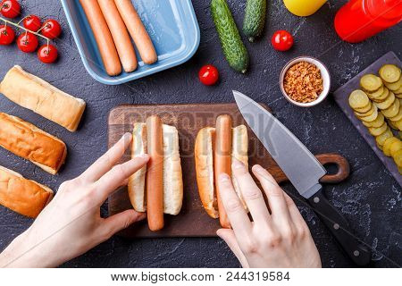 Picture From Above Of Man Doing Hotdogs On Table With Cutting Board