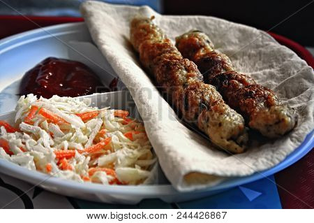 Portion Of Lula-kebab On Wheat Pita With Ketchup And Salad