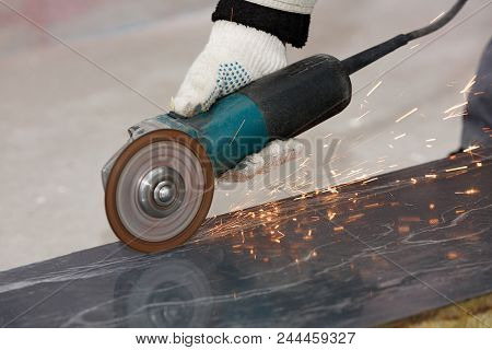 The Hand Of A Worker In A Glove Cuts The Building Material With An Angular Grinding Machine, Creatin