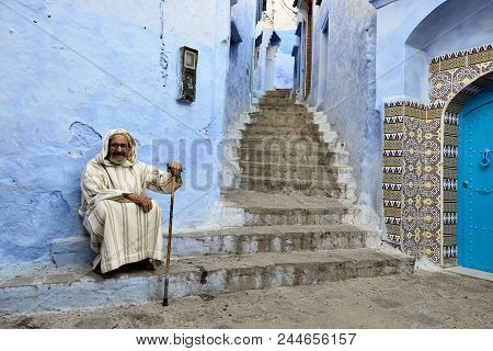Chefchaouen, Morocco - 27 November 2015:  Older Man Sitting On The Doorstep Of The House In The Blue