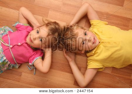 Брат и сестра лежат на полу