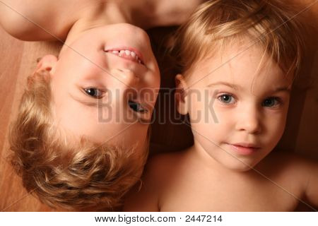 Двое детей лежат на полу