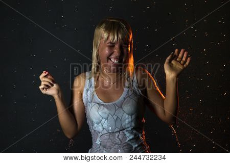 Nice Girl In The White Shirt And Water Drops Behind And Arround Her Illuminated By Light During A Ph