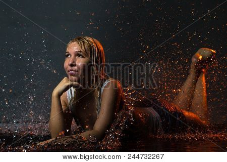 Nice Girl In The White Shirt And Water Drops Behind And Arround Her Illuminated By Light During A Ph