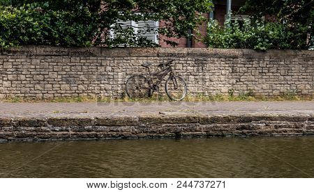 A Rusty Old Bike Is Abandoned At The Side Of The Towpath On The Canal