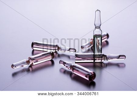 Glass Ampoules On The Table. Scattered Ampoules With Medicine. Medical Ampoules Close Up. Many Ampou
