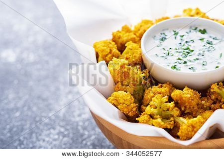 Cauliflower With Sour Cream Sauce On White Kraft Paper On Gray Background With Copy Space