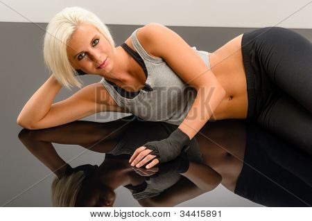 Mujer kickboxer establecen en plexiglás negro en el gimnasio