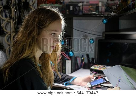 image of a girl doing school homework in the evening