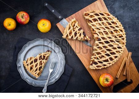 Traditional apple jalousie cake offered as top view on a modern design wooden board and pewter plate 
