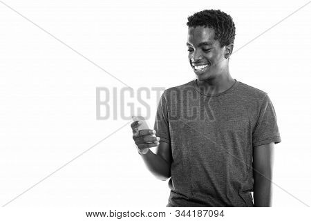 Studio Shot Of Young Hpapy Black African Teenage Boy Smiling While Using Mobile Phone