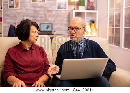 Elderly Old Couple Using Modern Laptop To Chat With Their Grandson