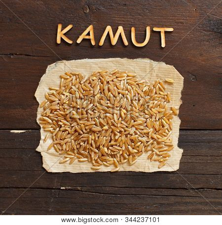 Pile Of Kamut Grain On Wooden Background Top View