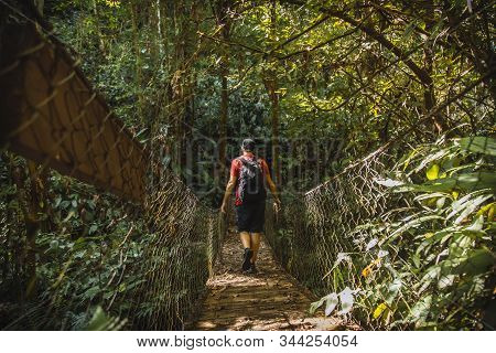 A Young Man Walking Along A Beautiful Wooden Bridge In The Cerro Azul Meambar National Park (panacam