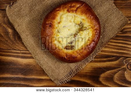 Sweet Round Bun With Cottage Cheese And Raisins (cheesecake) On Wooden Table. Top View