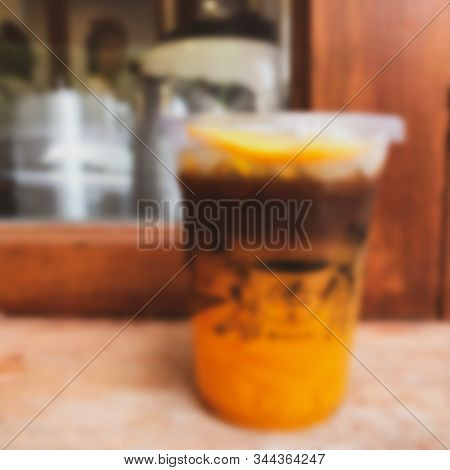 Blur Background Of A Glass Of Espresso Shot Mixed With Craft Soda And Orange Juice