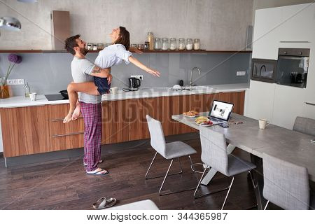 happy young  couple in morning celebratin valentines day in kitchen. sexy and in love