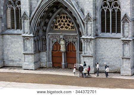 Guide and tourists at the temple, miniature scene