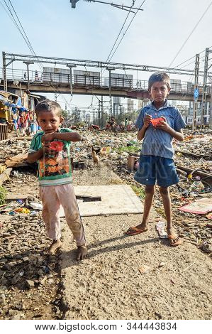 Mumbai, India - February 26, 2019: Indian Young Boys Eating Near Suburban Railway In Dharavi Slum At