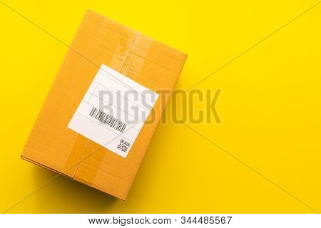 Top View Empty Brown Post Or Carton Box On Yellow Paper Background