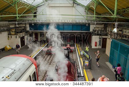 London, Uk - June 22, 2019:  Vintage Steam Train Stopped Next To Modern District Line Train At Ealin