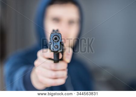 Crime Or Robbery Concept: Man With Black Gun Is Aiming With His Weapon