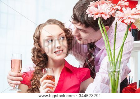 A Young Man, An Employee Of The Company Shows Courtship To His Colleague-a Young Woman With Curly Ha