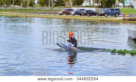 Mackay, Queensland, Australia - January 2020: A Child Wearing A Safety Helmet And Life Jacket Enjoyi