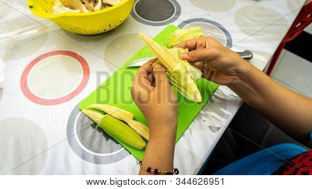 Close Up Hand Taking Out The Baby Corn Cover To Get The Corn For Cooking Ingredients For Making Vege
