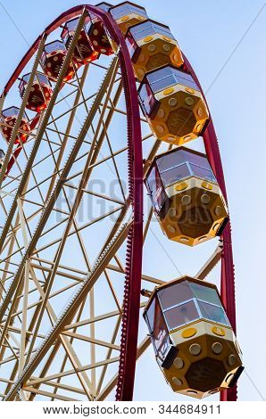 Ferris Wheel In The Park Against The Blue Sky