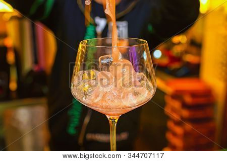 Preparation Of A Cocktail By A Bartender From Ice Cubes Of Alcohol And Juice.