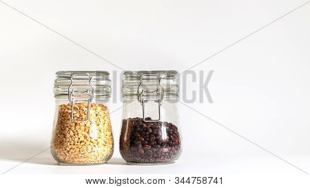 Red Beans And Yellow Chopped Peas Are Tightly Closed In A Glass Container. Legumes Are Stored In Ban