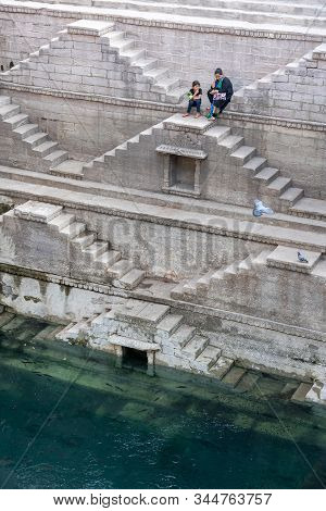 Jodhpur, India - December 8, 2019: A Mother And Her Daughter Sitting On The Steps Of The Stepwell To
