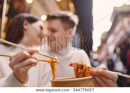 Newlywed Couple Eating Noodles With Chopsticks In Shanghai Outside A Food Market