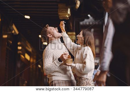 Newlywed Couple Eating Noodles With Chopsticks In Shanghai Outside A Food Market
