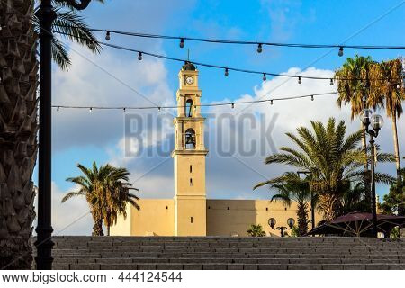 Bell tower of catholic cathedral. The wide stone erased steps of the ancient city. Sunset. Old Yaffo - one of the most ancient cities of the world. Concept active, informative and photo of tourism