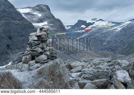 Stone Mound With Dramatic Mountain Scenery In The Back On The Hiking Trail To Trollvegen In Norway. 