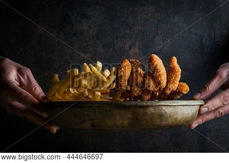 Side Vew Chicken Nuggets With French Fries And Human Hand In Clay Dishes On Stone Background