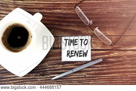 Time To Renew Text On Sticky With Coffee,pen And Glasses On Wooden Background