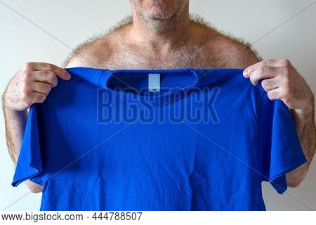 Man Holds T-shirt In  Hands. Man Wearing T-shirt