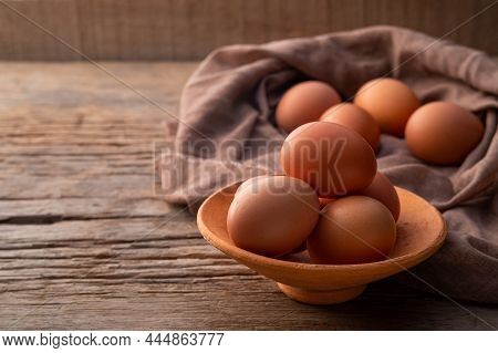 Chicken Eggs In Clay Bowl On Old Wood Table Background