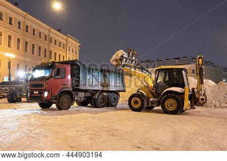 Snow Removal Equipment Working At Palace Square At Night After Heavy Snowfall. Snow Cyclone Or Blizz