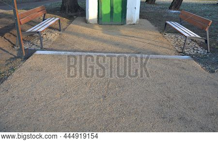 Under The Bench Are Rectangles Made Of Tiles. Otherwise, The Soft Surface Of The Compacted Gravel Pa