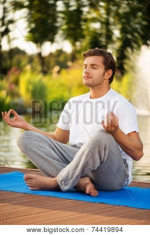 Young man maditating in lotus pose