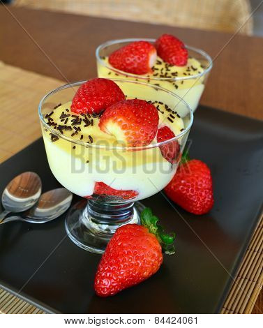 Vanilla pudding with fresh strawberries on the wooden table